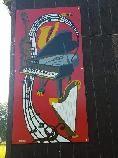 A graphic poster featuring a piano, harp, and saxophone against a red background.